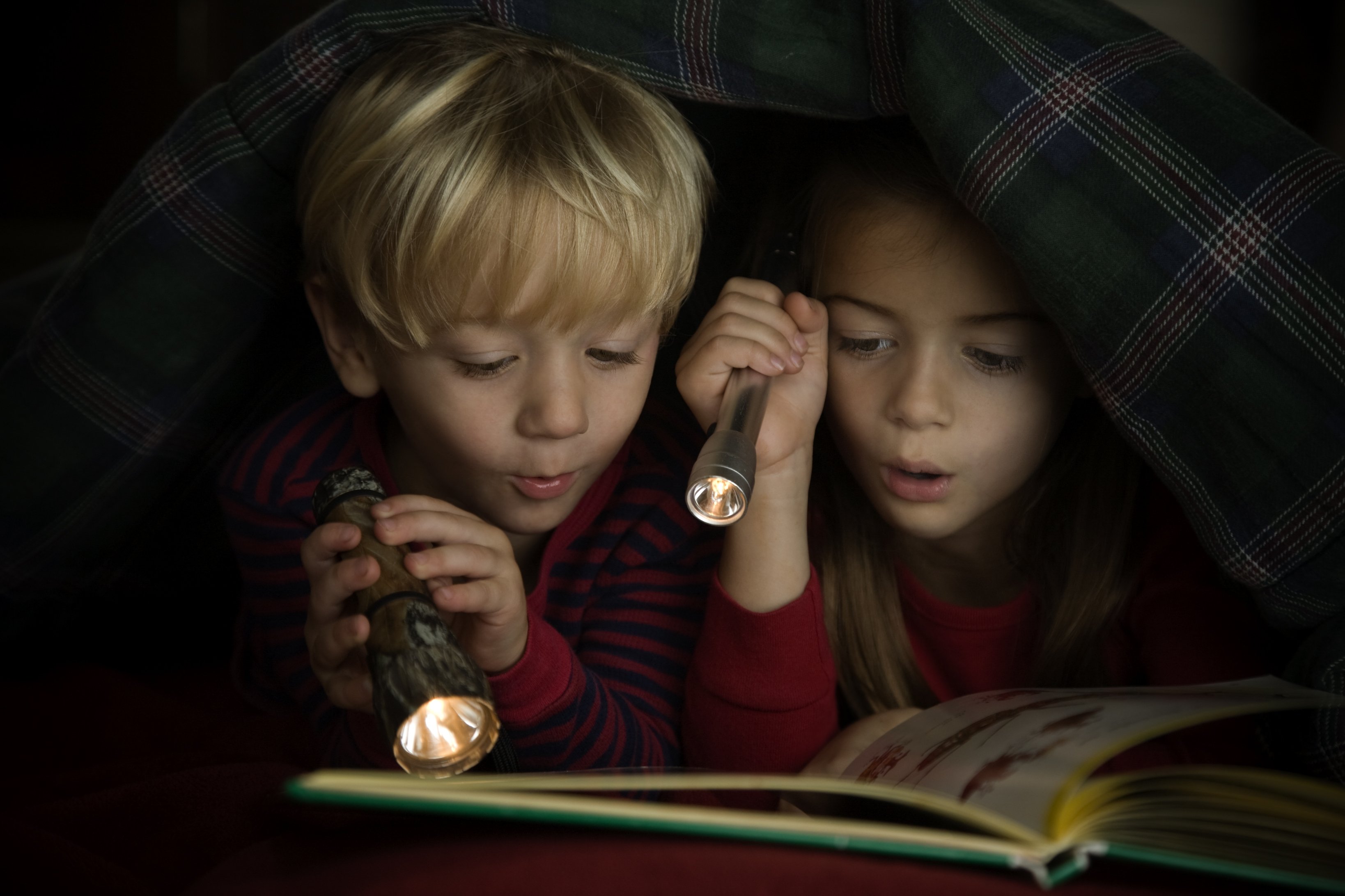 Почему при слабом свете. Чтение в темноте. Ребенок с фонариком в темноте. Чтение под одеялом с фонариком. Чтение книги в темноте.